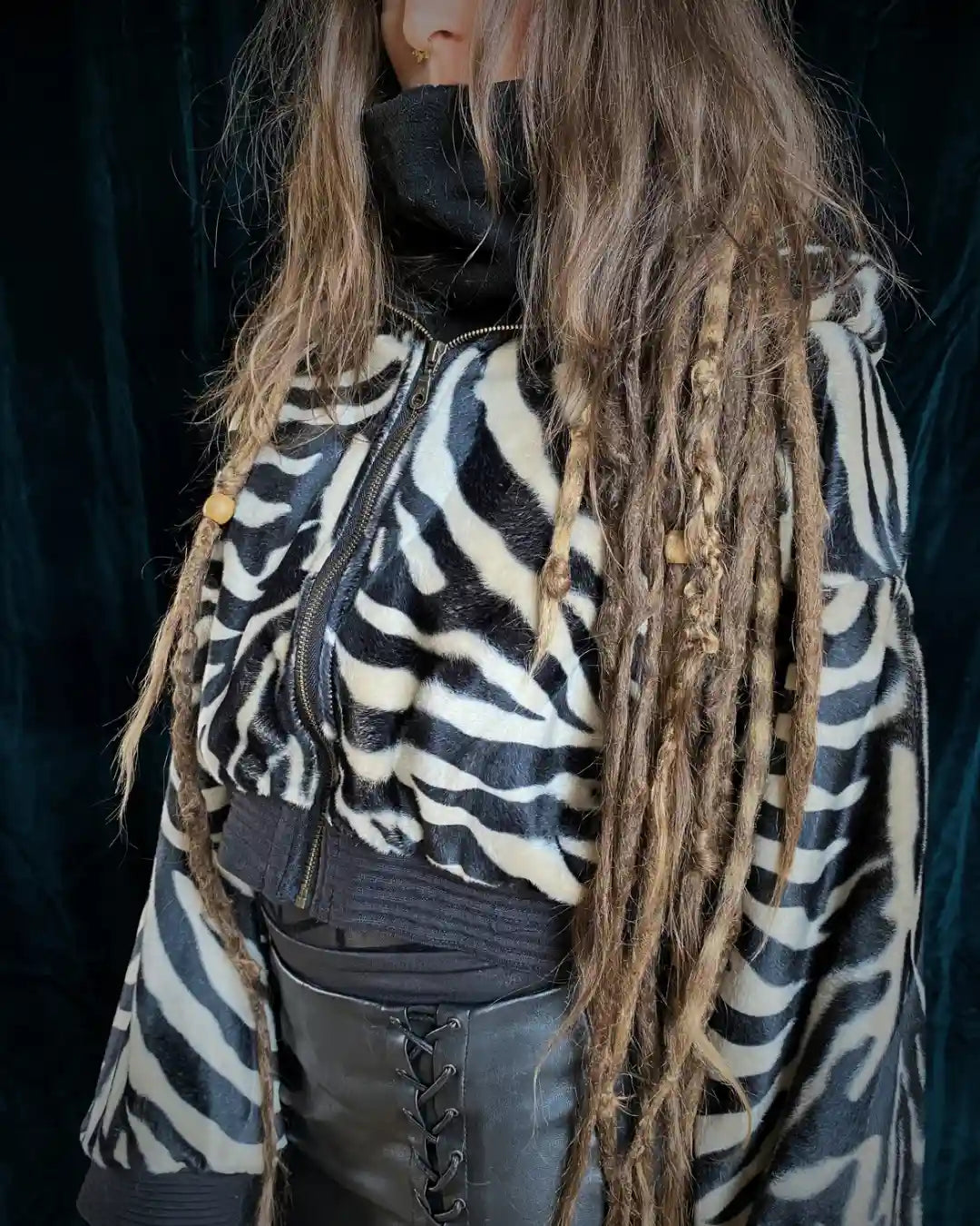 IUVA CRAFT STUDIO handgefertigte Zebra Kunstfelljacke – edle kurz geschnittene Felljacke mit schwarz-cremefarbenem Muster, perfekt für alternative Streetwear und Techno-Raves. IUVA CRAFT STUDIO handmade zebra faux fur jacket – elegant cropped jacket with black and cream pattern, ideal for alternative streetwear and techno rave fashion.