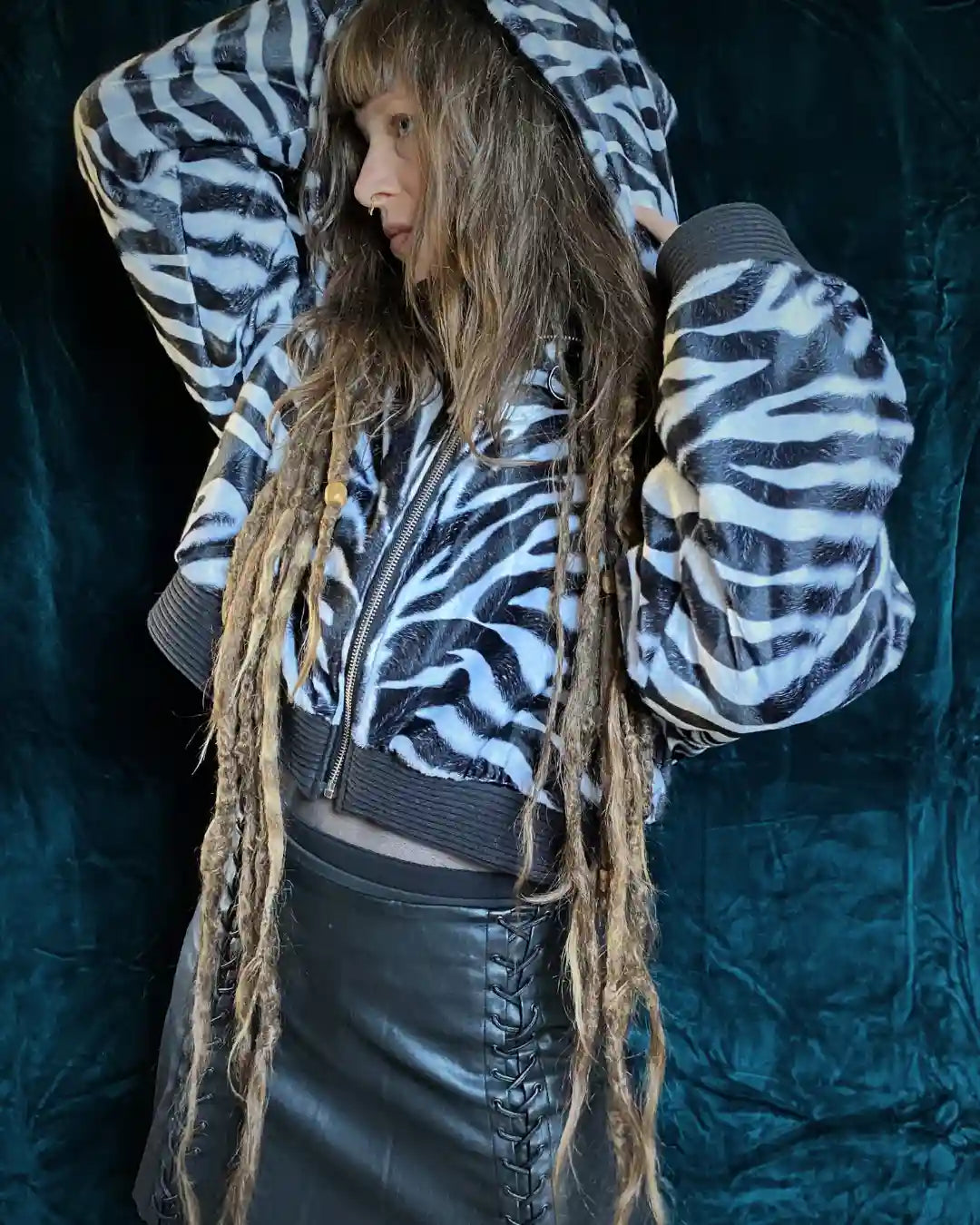 Handgefertigte Animalprint Zebra-Kunstfelljacke mit Kapuze, Reißverschluss und oversized fit – Slow Fashion Darkwear von IUVA CRAFT STUDIO.